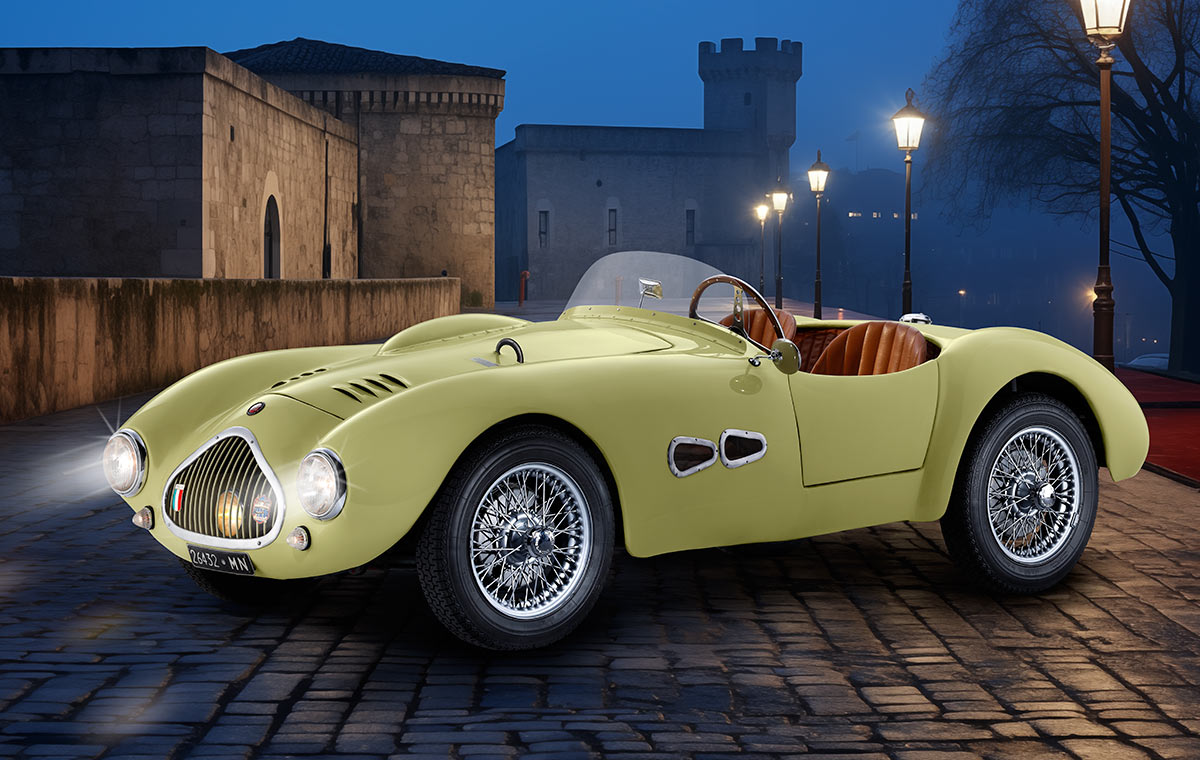 Ein klassisches, hellgelbes Sportauto mit runden Scheinwerfern und einer offenen Karosserie steht auf einem gepflasterten Platz bei Dämmerung. Im Hintergrund sind Straßenlaternen und eine alte Gebäudeansicht zu sehen.