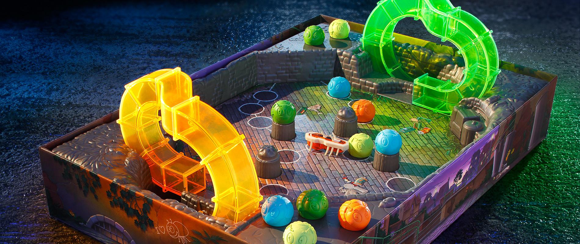 Ein Spielbrett mit bunten, transparenten Elementen in Form von Bögen und Kugeln. Das Design wirkt futuristisch, mit verschiedenen Farben und einer unregelmäßigen Anordnung auf der Spielfläche. Hintergrund dunkel und stimmungsvoll.